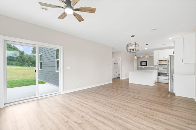 585 Cedar Dr, Lake City, MN 55041 - unfurnished living room featuring light wood-style flooring, a ceiling fan, a chandelier, and recessed lighting