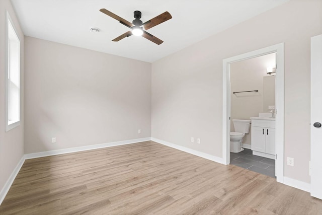 585 Cedar Dr, Lake City, MN 55041 - unfurnished bedroom featuring wood finished floors, connected bathroom, and ceiling fan