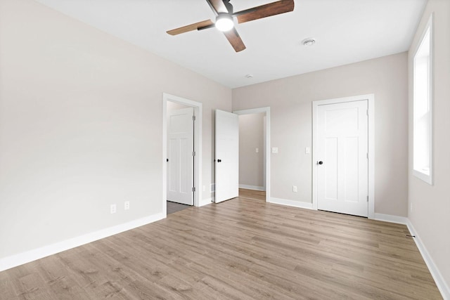 585 Cedar Dr, Lake City, MN 55041 - unfurnished bedroom featuring light wood-style flooring, multiple windows, and a ceiling fan
