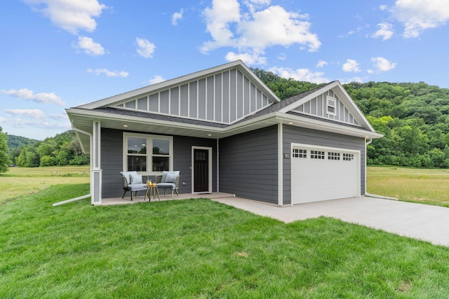 585 Cedar Dr, Lake City, MN 55041 - view of front of property with board and batten siding, an attached garage, a front yard, and concrete driveway