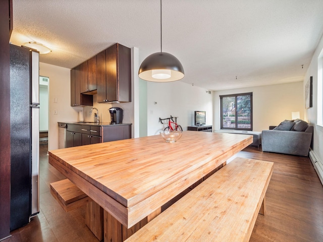 dining room featuring a textured ceiling and dark wood-style flooring