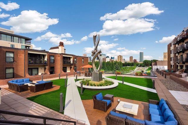 view of community with a lawn, an outdoor living space, and a city view