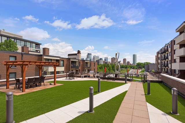 view of property's community with a city view, a yard, and a pergola