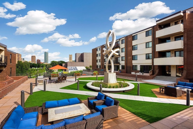 view of home's community featuring a patio area, a view of city, outdoor lounge area, and a lawn