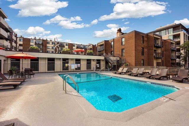 community pool featuring fence and a patio