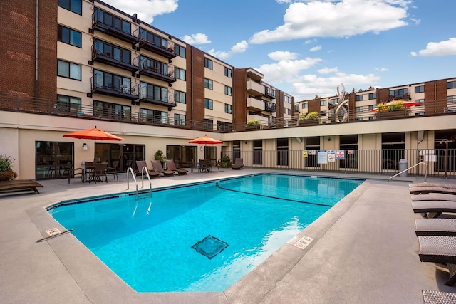 community pool with fence and a patio