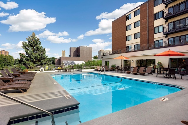 community pool with fence and a patio