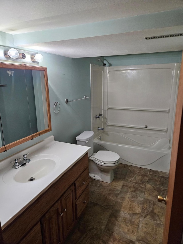 bathroom featuring shower / bathing tub combination, vanity, toilet, and a textured ceiling