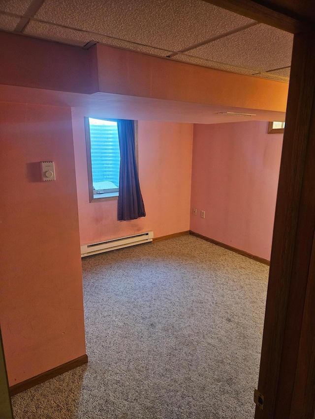 carpeted empty room featuring baseboards and a baseboard heating unit