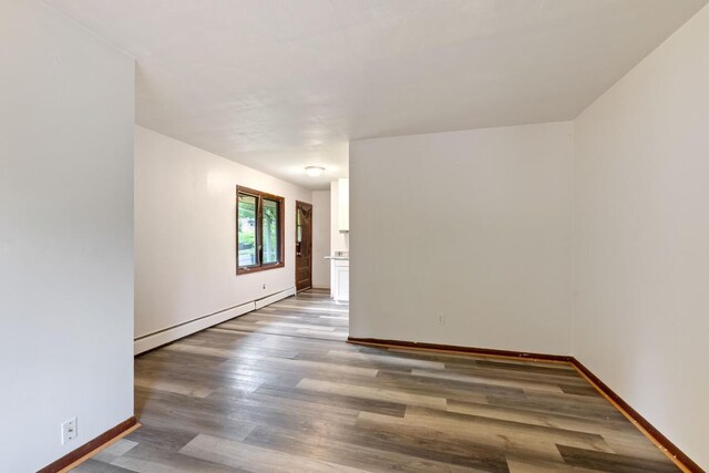 1022-1024 34th Ave N, Minneapolis, MN 55412 - unfurnished room featuring a baseboard heating unit, wood finished floors, and baseboards
