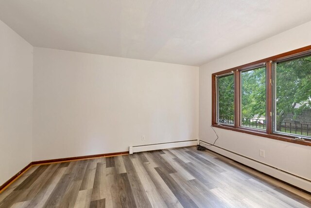 1022-1024 34th Ave N, Minneapolis, MN 55412 - spare room with wood finished floors, a baseboard radiator, and baseboards