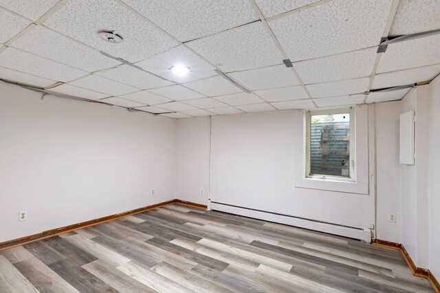 1022-1024 34th Ave N, Minneapolis, MN 55412 - unfurnished room featuring baseboard heating, wood finished floors, and baseboards