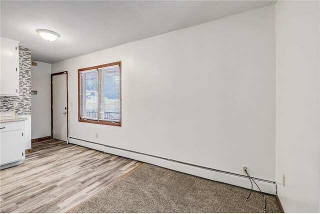 1022-1024 34th Ave N, Minneapolis, MN 55412 - unfurnished dining area with a baseboard radiator and light wood-style flooring