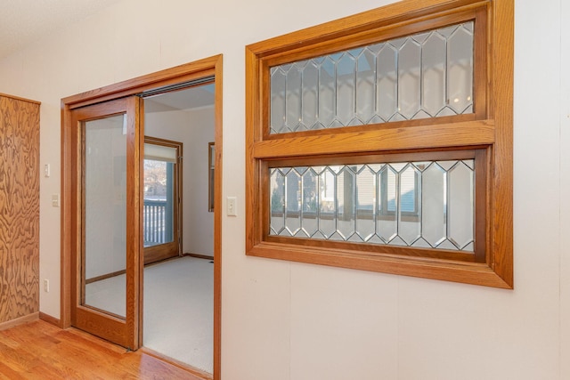 hallway featuring light wood-type flooring and baseboards