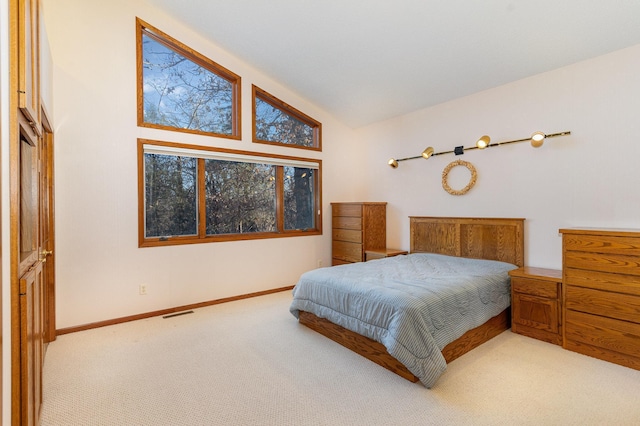 bedroom featuring lofted ceiling, carpet flooring, visible vents, and baseboards