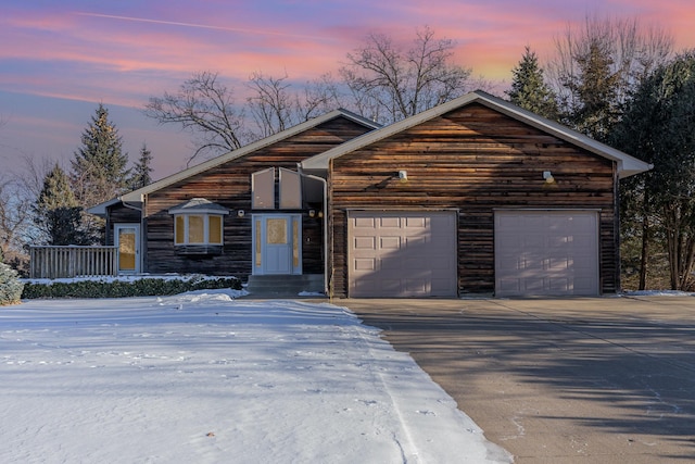 chalet / cabin with driveway and an attached garage