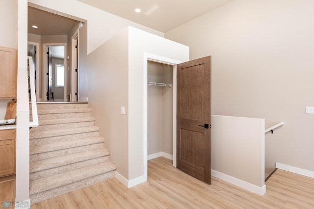 staircase featuring recessed lighting, baseboards, and wood finished floors