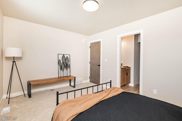 bedroom with light colored carpet, visible vents, and baseboards