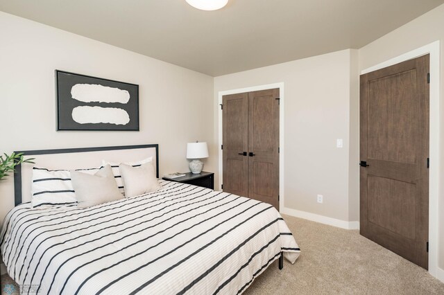 carpeted bedroom featuring a closet and baseboards