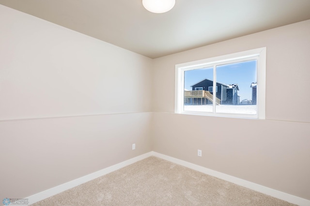 empty room with carpet and baseboards