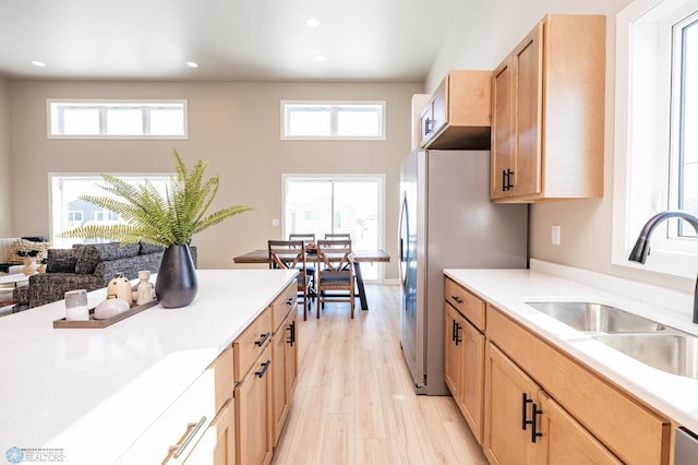 kitchen featuring light brown cabinets, light countertops, light wood-style floors, and a sink