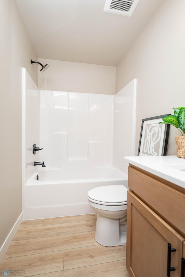 full bath featuring vanity, wood finished floors, visible vents, shower / washtub combination, and toilet