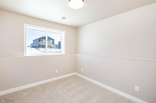 carpeted empty room with baseboards