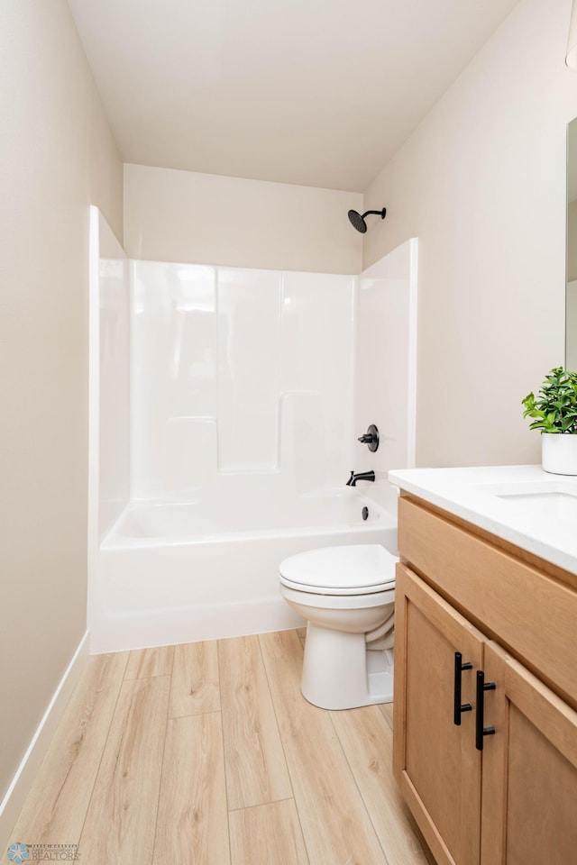 bathroom featuring toilet, vanity, shower / bathing tub combination, and wood finished floors