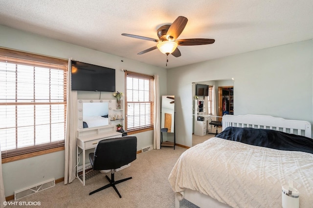 bedroom with light carpet, baseboards, visible vents, and a textured ceiling