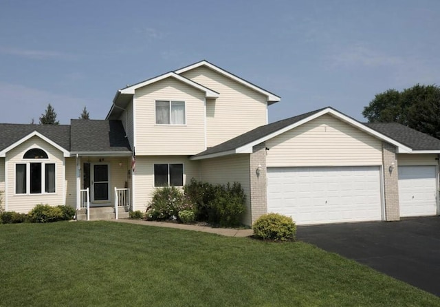 view of front facade featuring aphalt driveway, an attached garage, brick siding, and a front yard