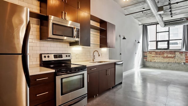 kitchen with appliances with stainless steel finishes, light countertops, a sink, and open shelves