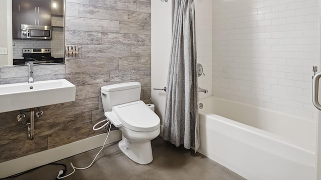 full bathroom with toilet, concrete floors, a sink, tile walls, and shower / bathtub combination with curtain