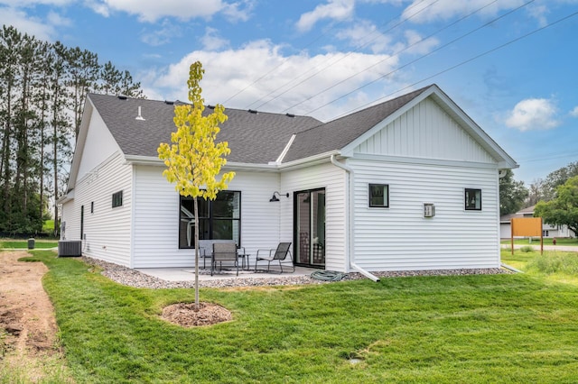 rear view of house featuring a patio, central AC, a shingled roof, a lawn, and board and batten siding