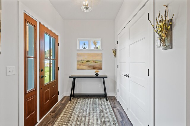 doorway to outside featuring dark wood-style floors and baseboards