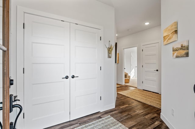 foyer featuring dark wood-type flooring, recessed lighting, and baseboards