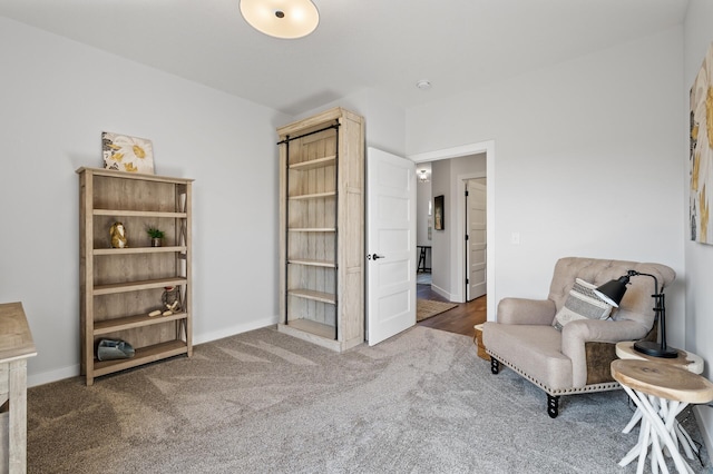 living area featuring carpet and baseboards