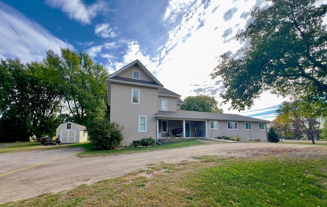 view of front of property with an outbuilding, a front yard, and a storage unit