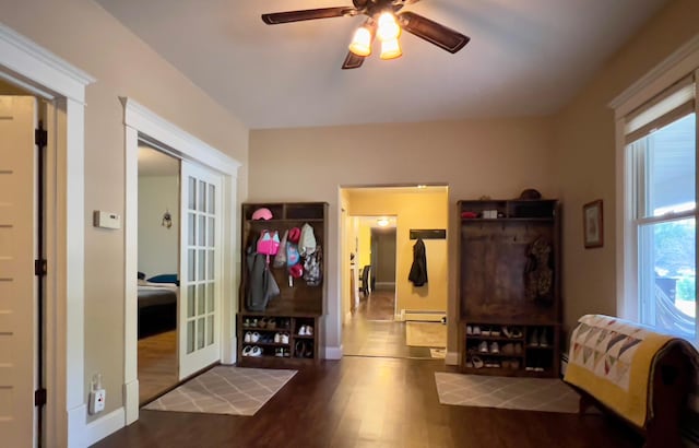 interior space featuring dark wood-style flooring, baseboards, ceiling fan, and baseboard heating