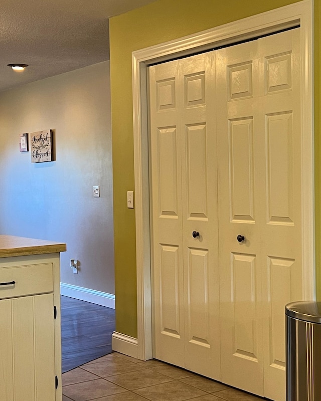 interior space featuring baseboards and tile patterned floors