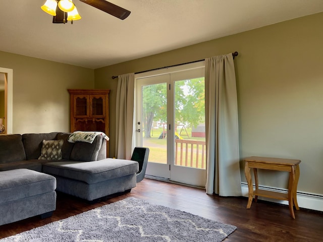 living area featuring a ceiling fan, baseboard heating, and dark wood-type flooring