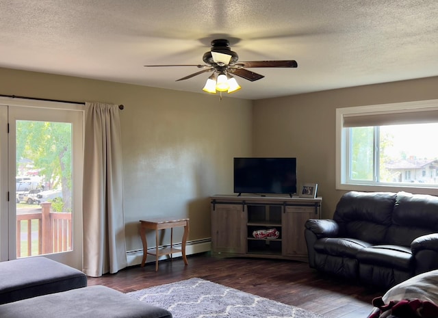 living room with dark wood-style floors, a ceiling fan, baseboard heating, and a textured ceiling