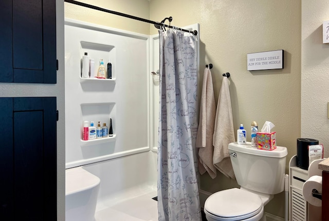 bathroom featuring a textured wall, a shower stall, and toilet