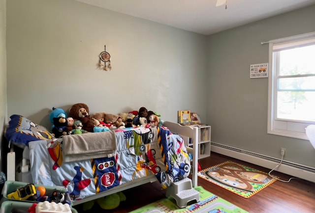 game room with a baseboard radiator, wood finished floors, and a ceiling fan