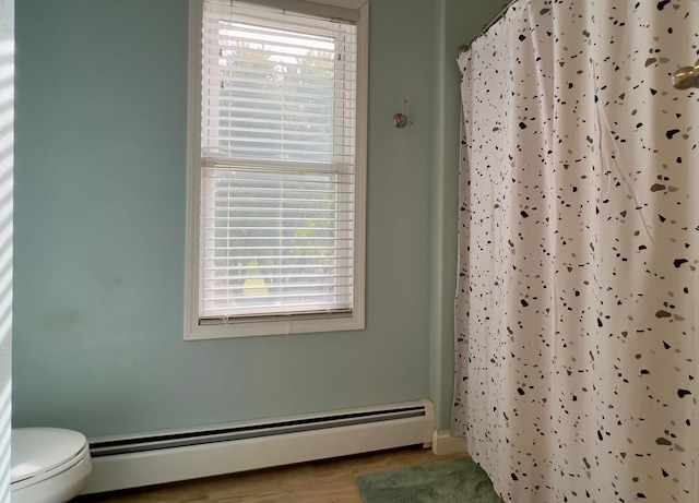 bathroom featuring toilet, a baseboard radiator, and a shower with shower curtain