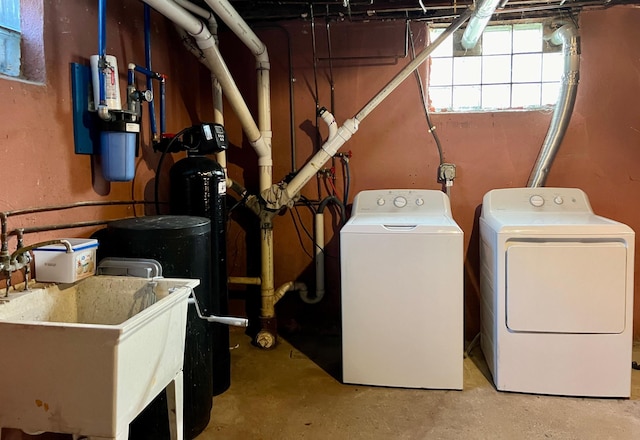 washroom featuring laundry area, washer and clothes dryer, and a sink