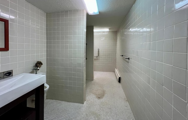 bathroom featuring a textured ceiling, walk in shower, tile walls, and tile patterned floors