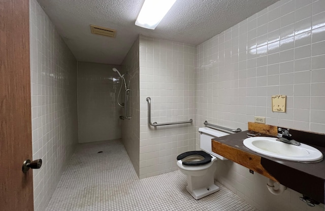 bathroom with tile walls, toilet, a stall shower, a textured ceiling, and tile patterned flooring