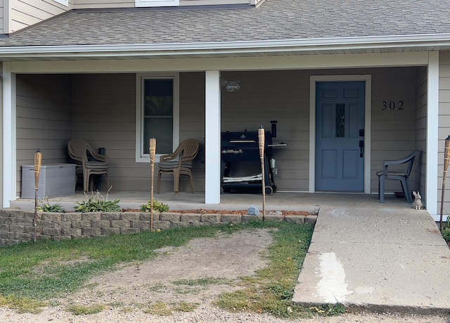 property entrance featuring a shingled roof