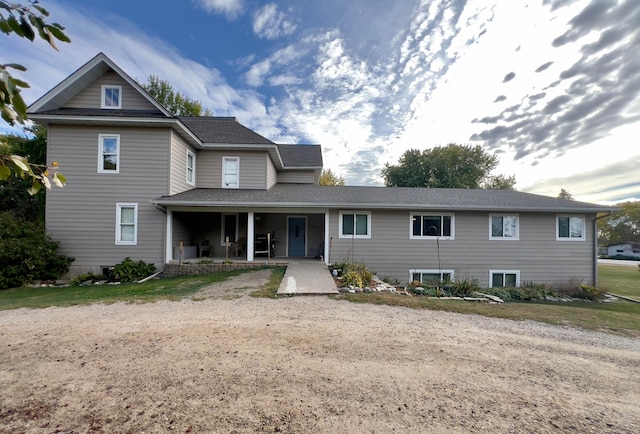 view of front of house featuring roof with shingles and a patio