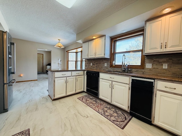 kitchen with dishwasher, dark countertops, freestanding refrigerator, a peninsula, and a sink